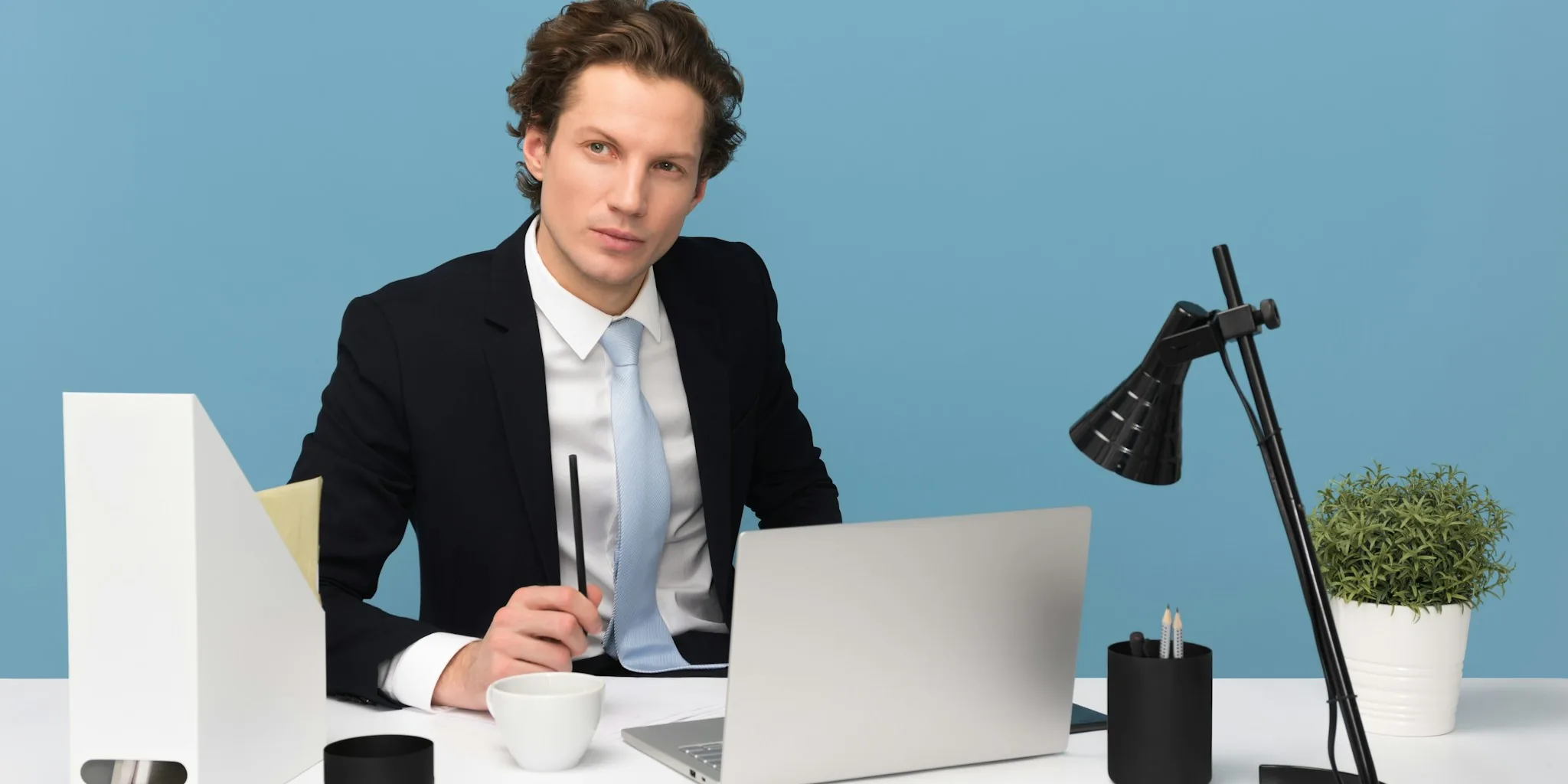 Professional working at organized computer desk with dual monitors and natural lighting