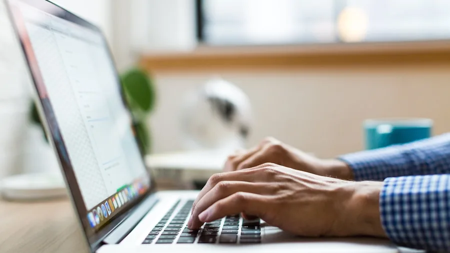 Professional working on laptop during extended work session in modern office environment