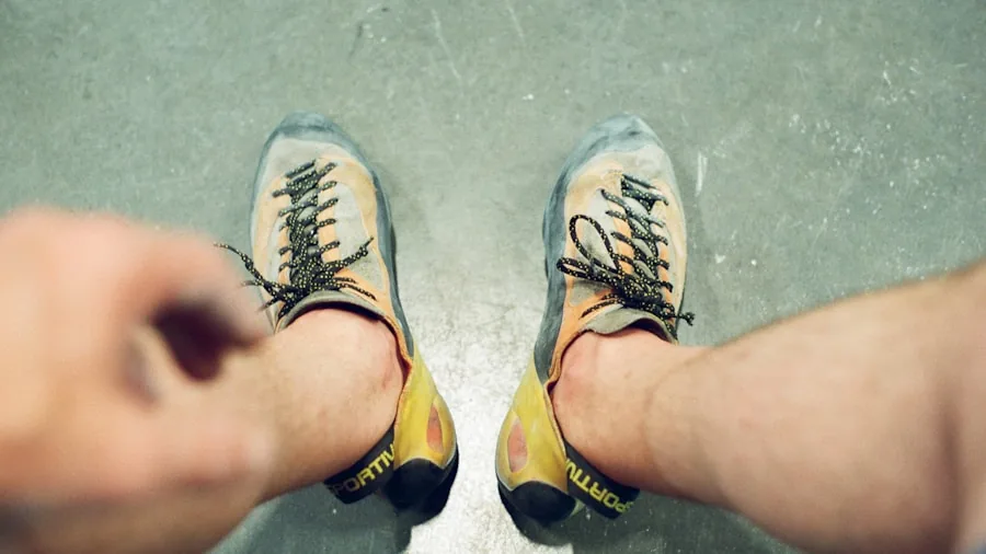 The %product_count% Best Climbing Shoes 2 Rock climber adjusting and testing shoe fit before climbing at indoor gym