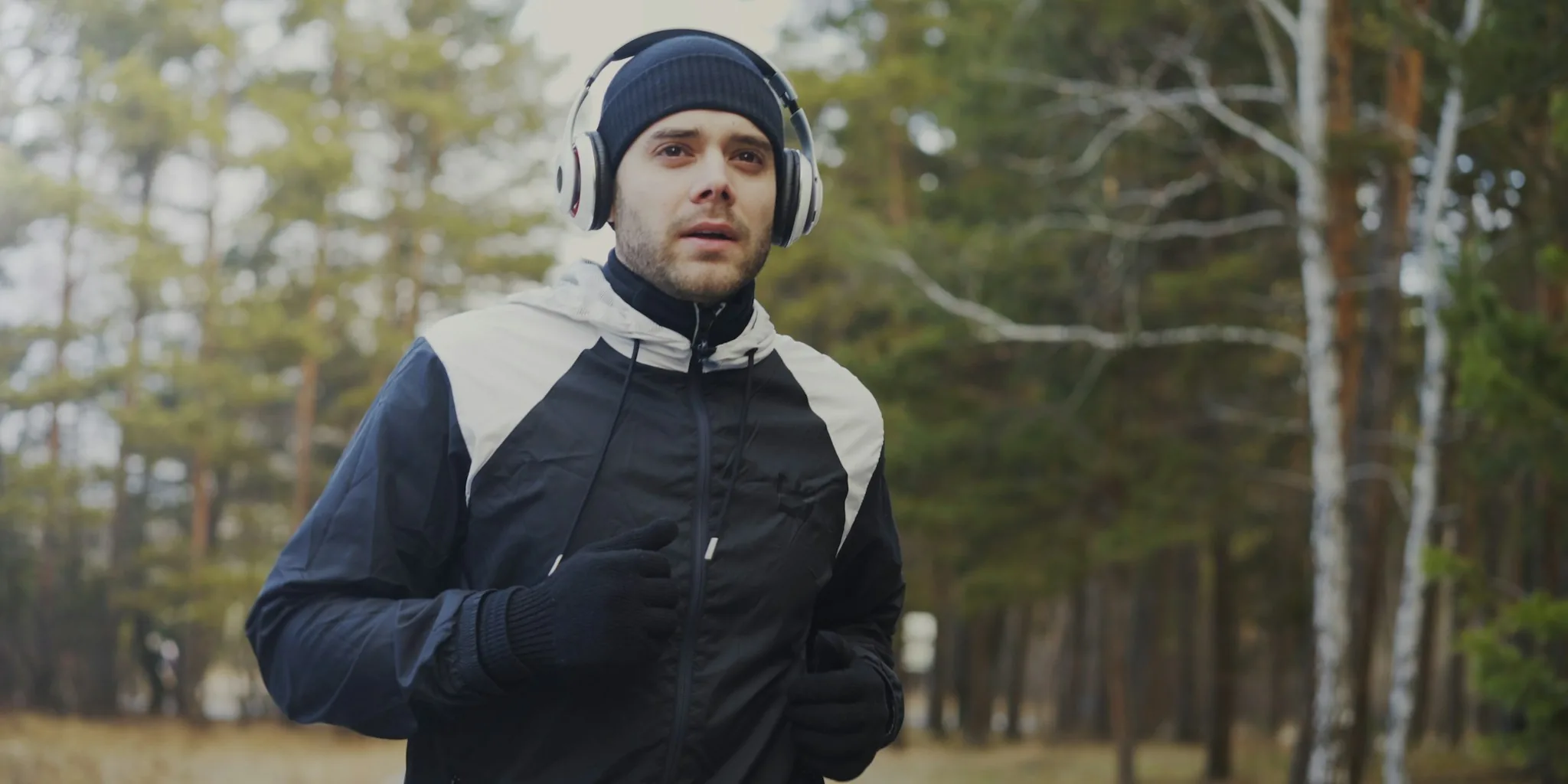 Runner jogging outside wearing wireless headphones during morning exercise session