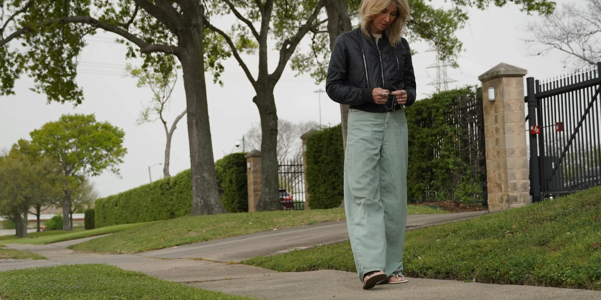 Senior person holding and looking at smartphone in natural daylight