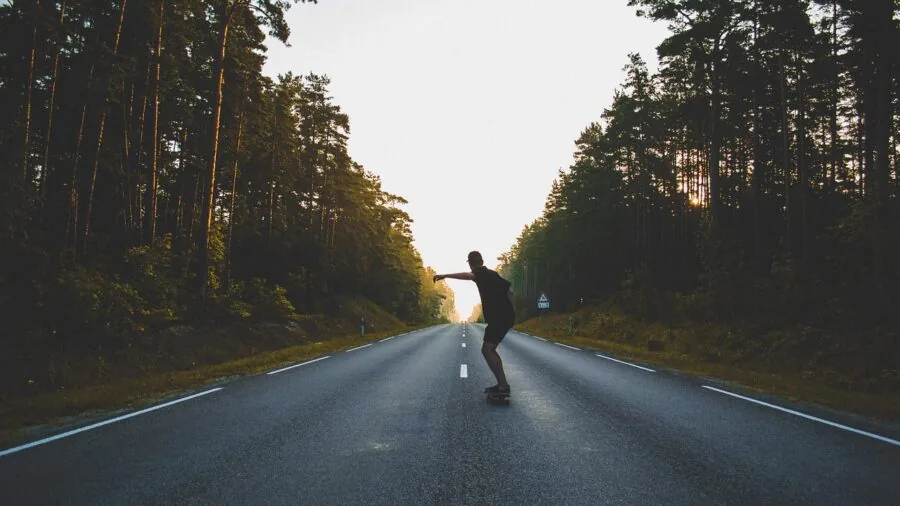 Skateboarder riding smoothly on clean pavement, demonstrating cruising technique and board control