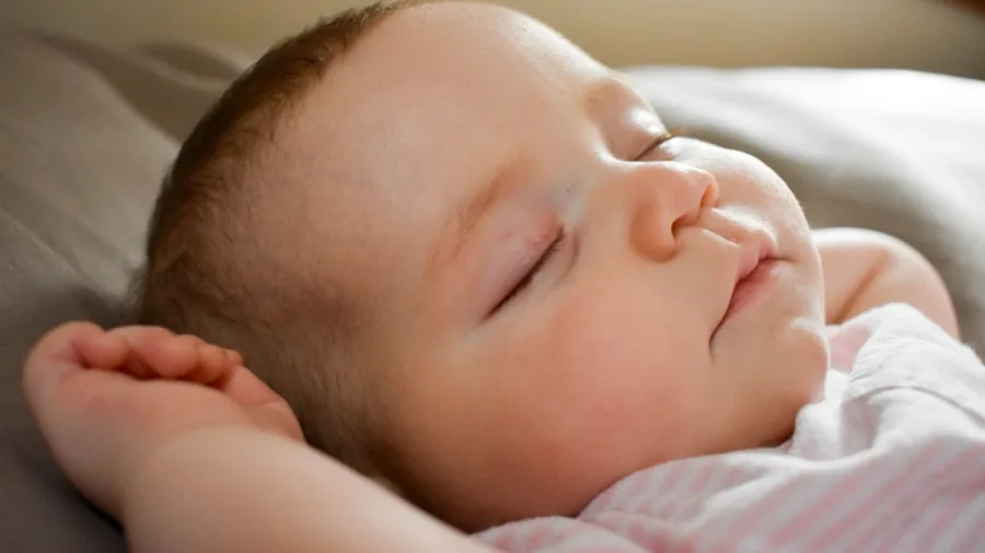 Sleeping infant in crib during nighttime, illustrating overnight diaper performance needs