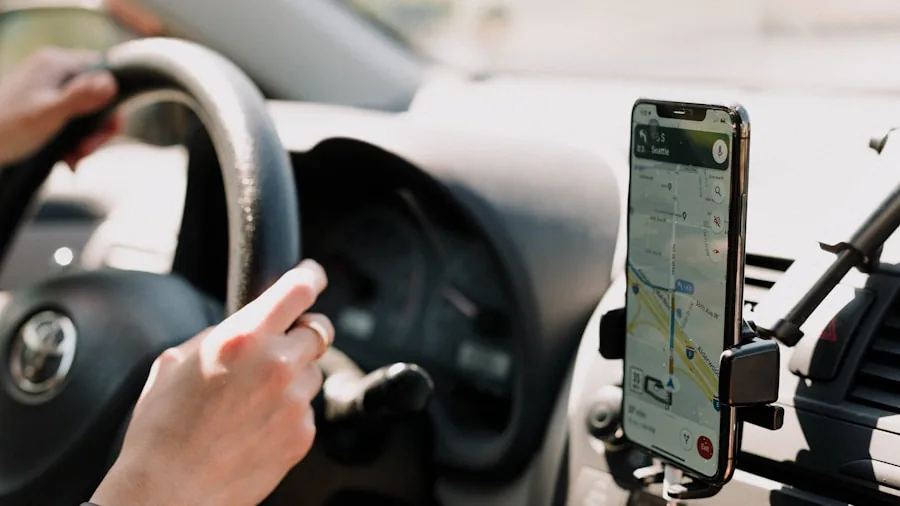 Smartphone mounted on car dashboard displaying navigation map during daytime driving