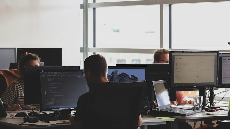 Software developer typing on laptop at desk with focused concentration during coding work session
