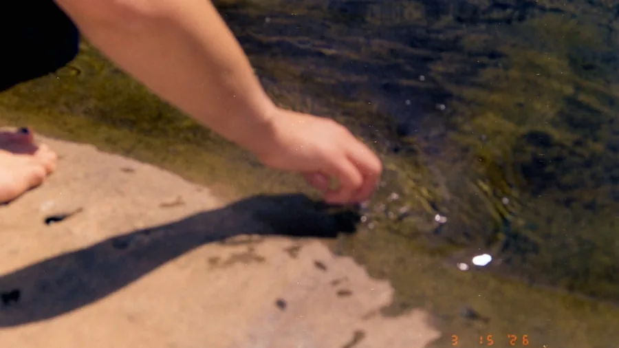 Someone washing a dirty outdoor surface with water pressure, demonstrating cleaning in action