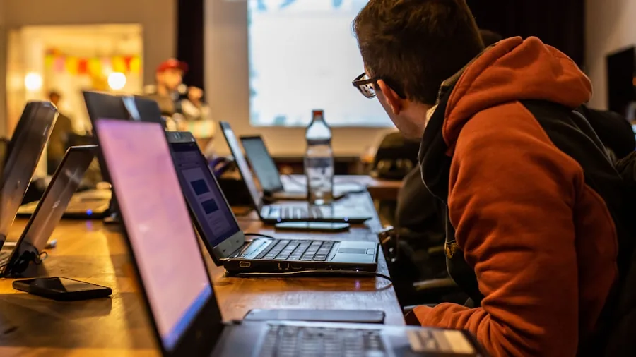Student studying at laptop in bright classroom environment with natural lighting