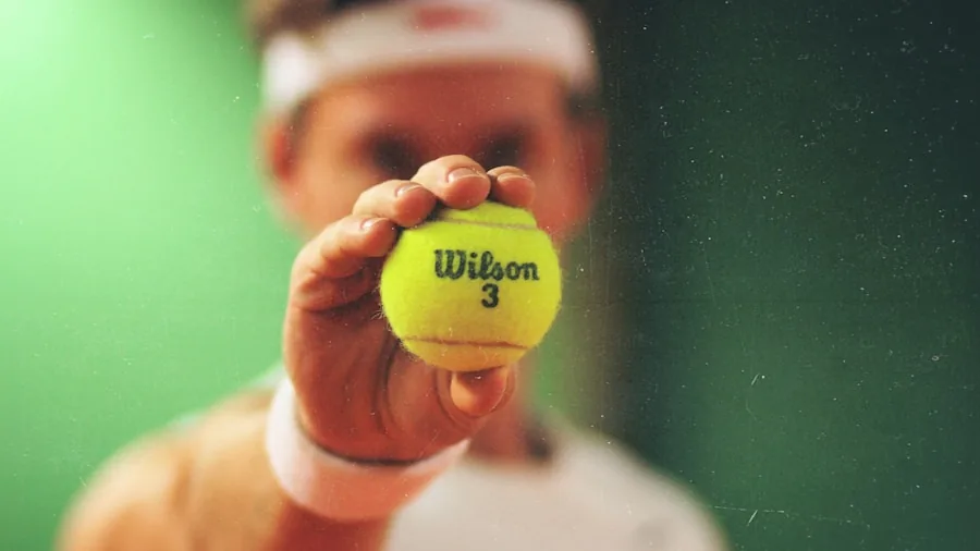 Tennis player examining racket weight and balance during outdoor court practice session