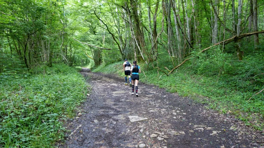 Trail runner navigating muddy forest path with varied terrain and natural ground surfaces