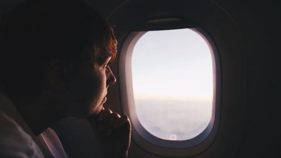 The 9 Best White Noise Machines 3 Traveler sleeping peacefully on airplane during flight with neck pillow and window seat