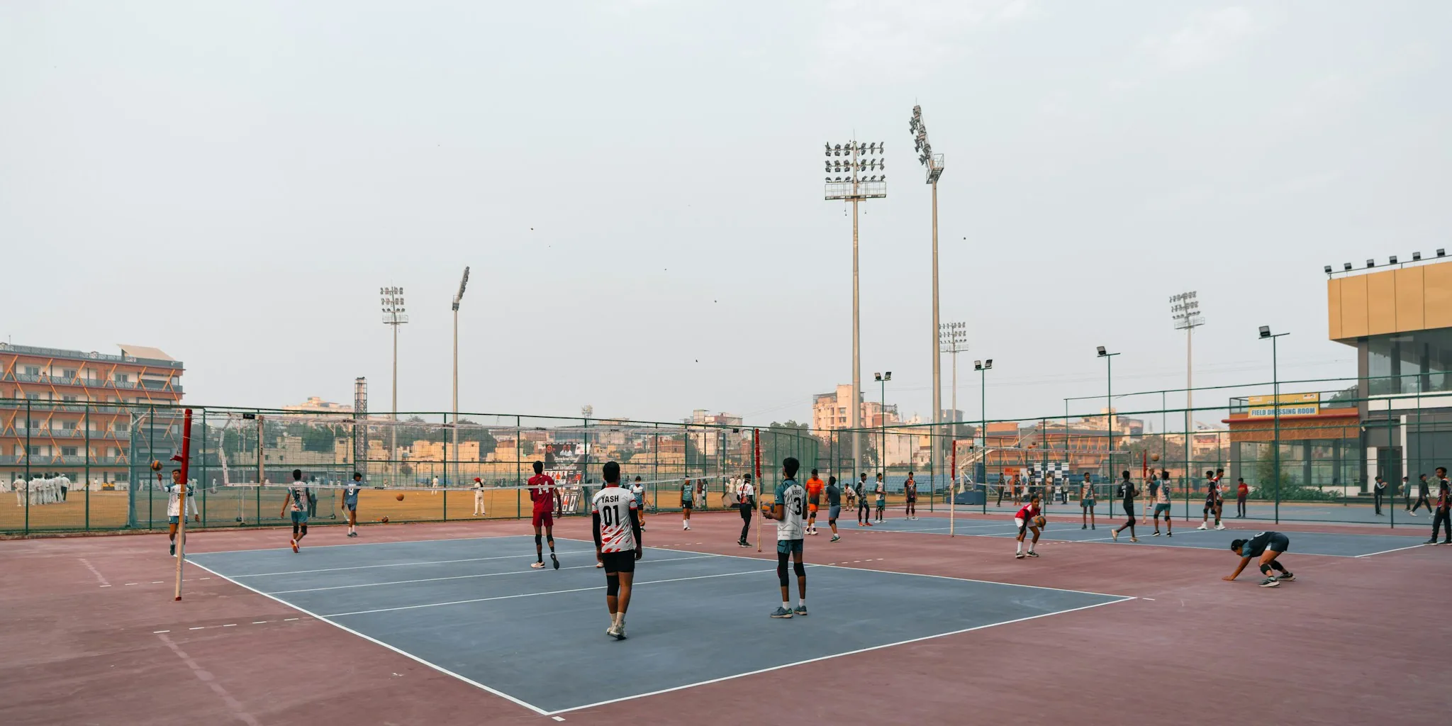 Two people playing pickleball on outdoor court with paddles and ball in action