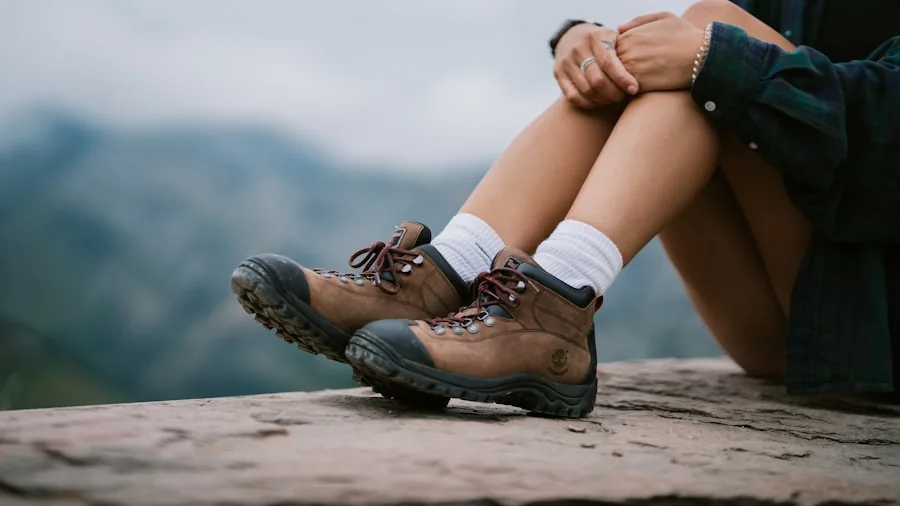 Woman examining fit of hiking boots while sitting outdoors, checking boot comfort and sizing