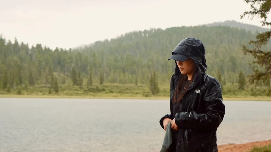 Woman maintaining and caring for rain jacket in natural outdoor setting