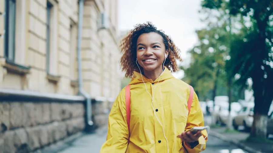 Woman wearing waterproof rain jacket during rainfall in natural outdoor setting