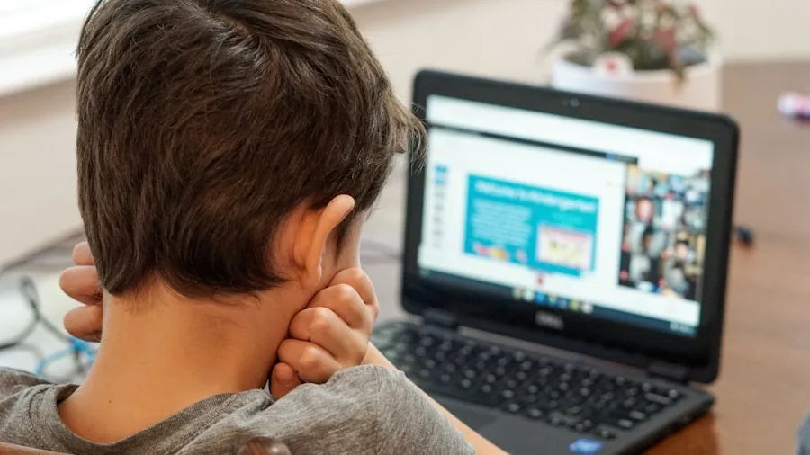 Young student engaged in virtual classroom session on computer at home desk